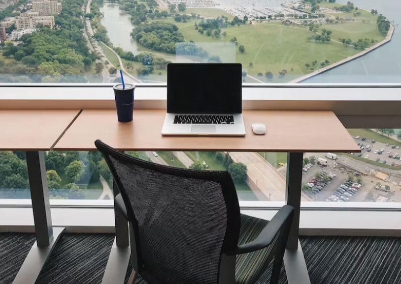 a computer on a desk near a window