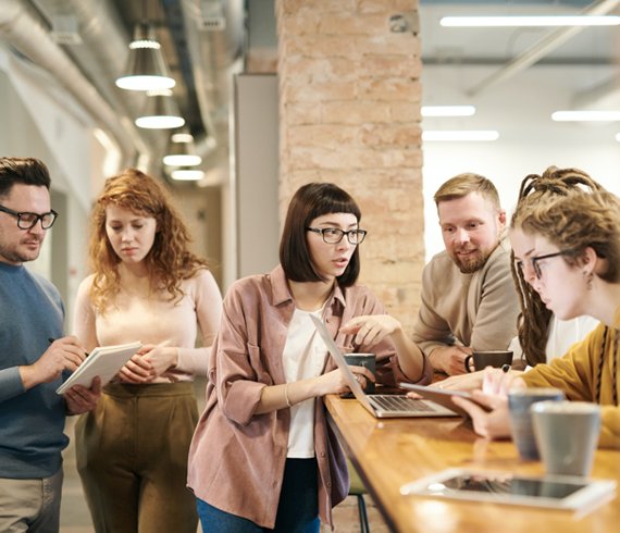 a group of people looking at a computer on a table