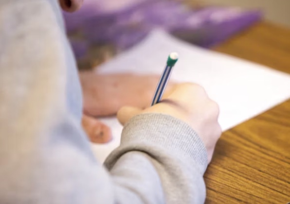 a person writing on a sheet of paper