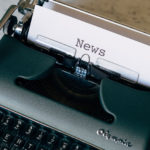 a typewriter with paper that says news in it