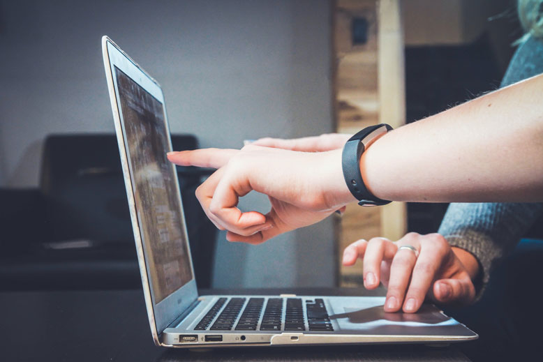 a person pointing at a computer screen