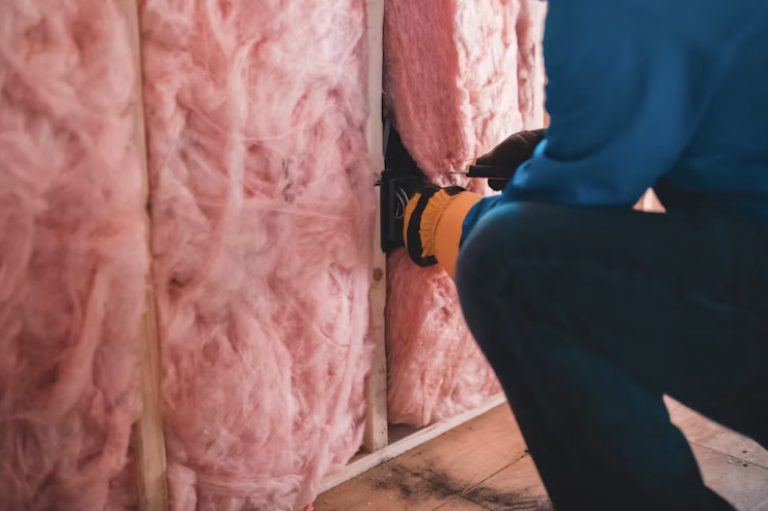 a person putting insulation in a wall