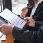 a hand with a pen pointing to a schedule on a to do list