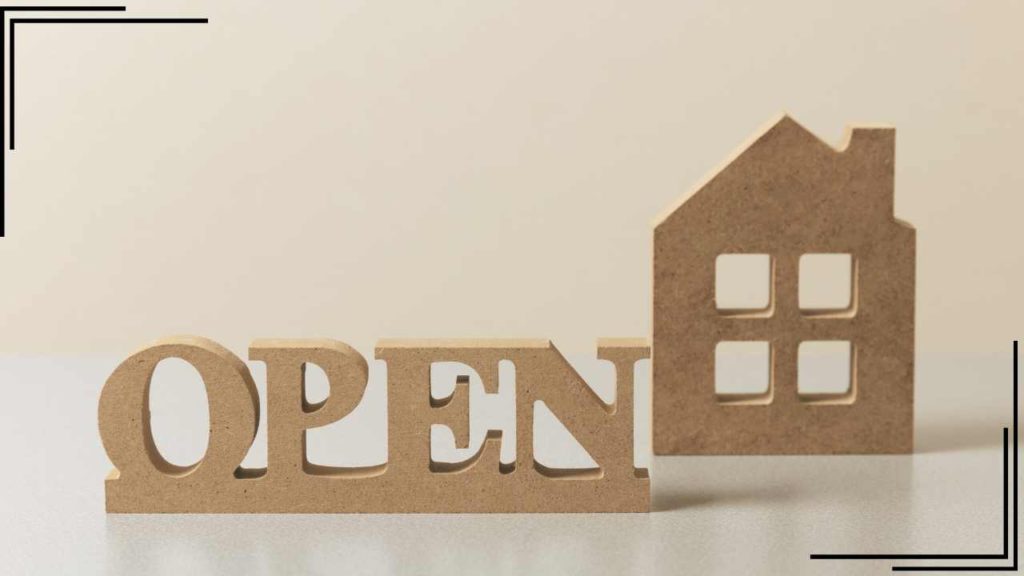 a wooden block with the word open next to a wooden house with a white background