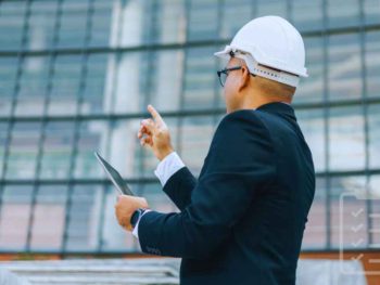 a person in front of a commercial building conducting a checklist